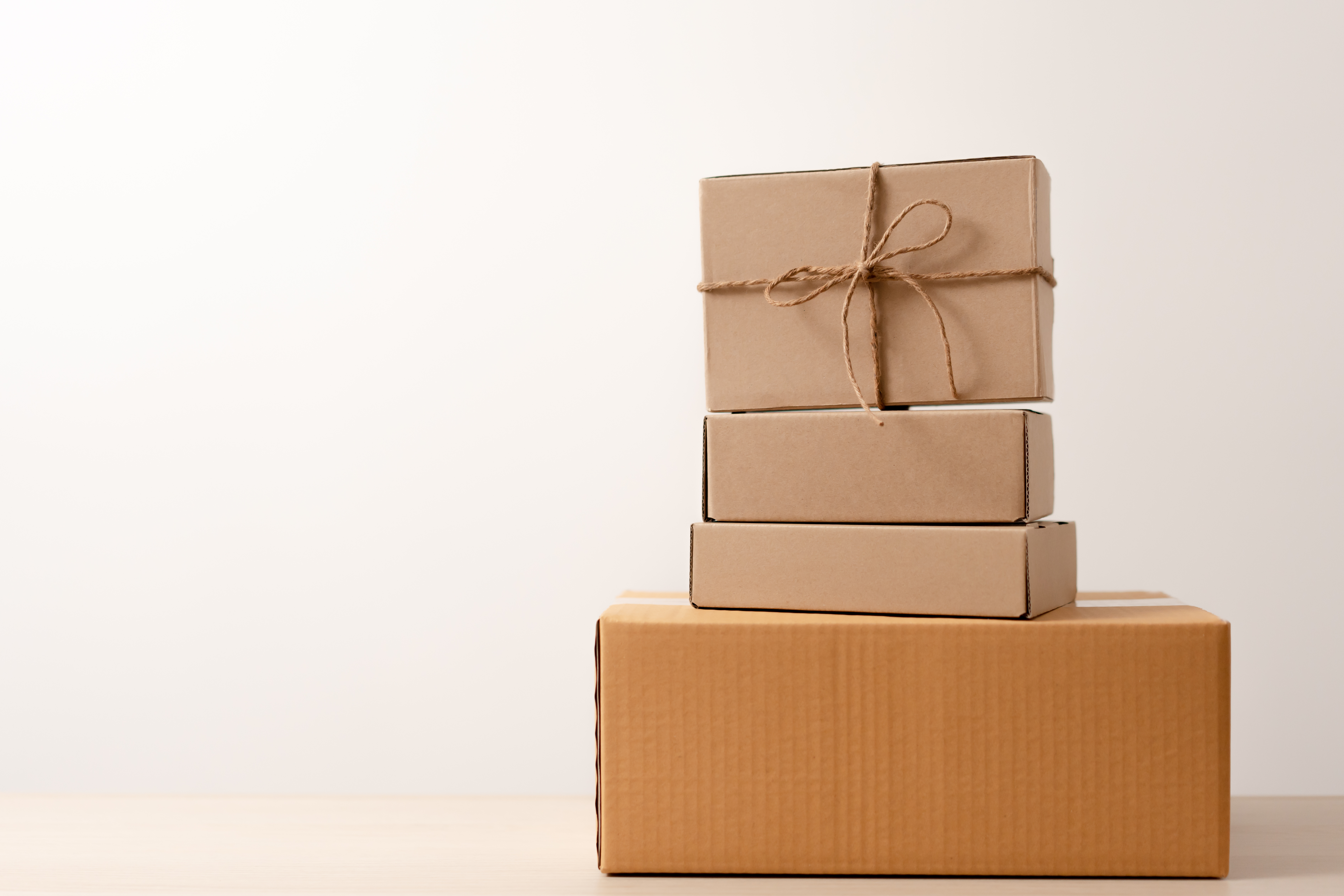 brown boxes stacked against a plain white wall