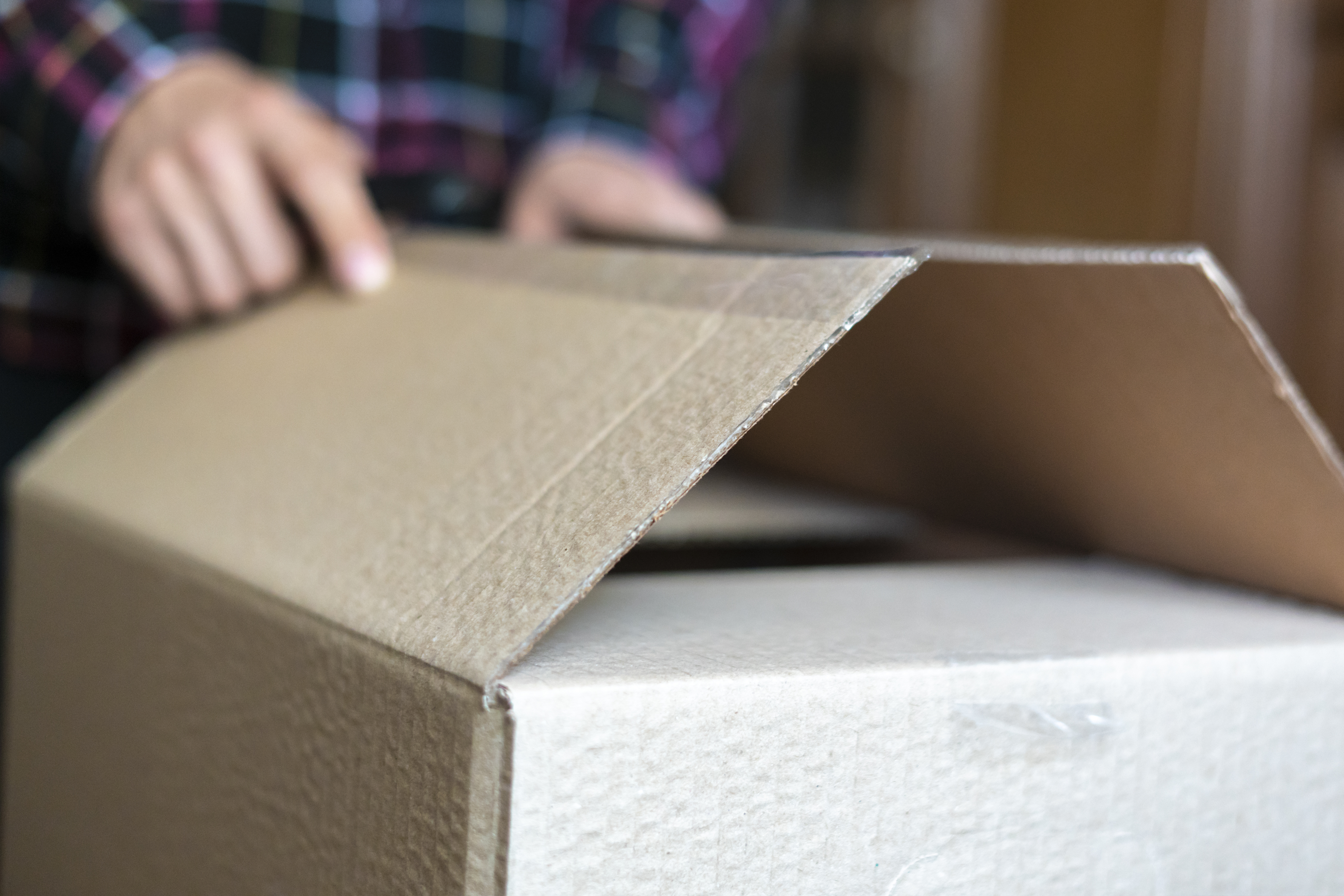 close up of a box being folded by someone out of frame.  