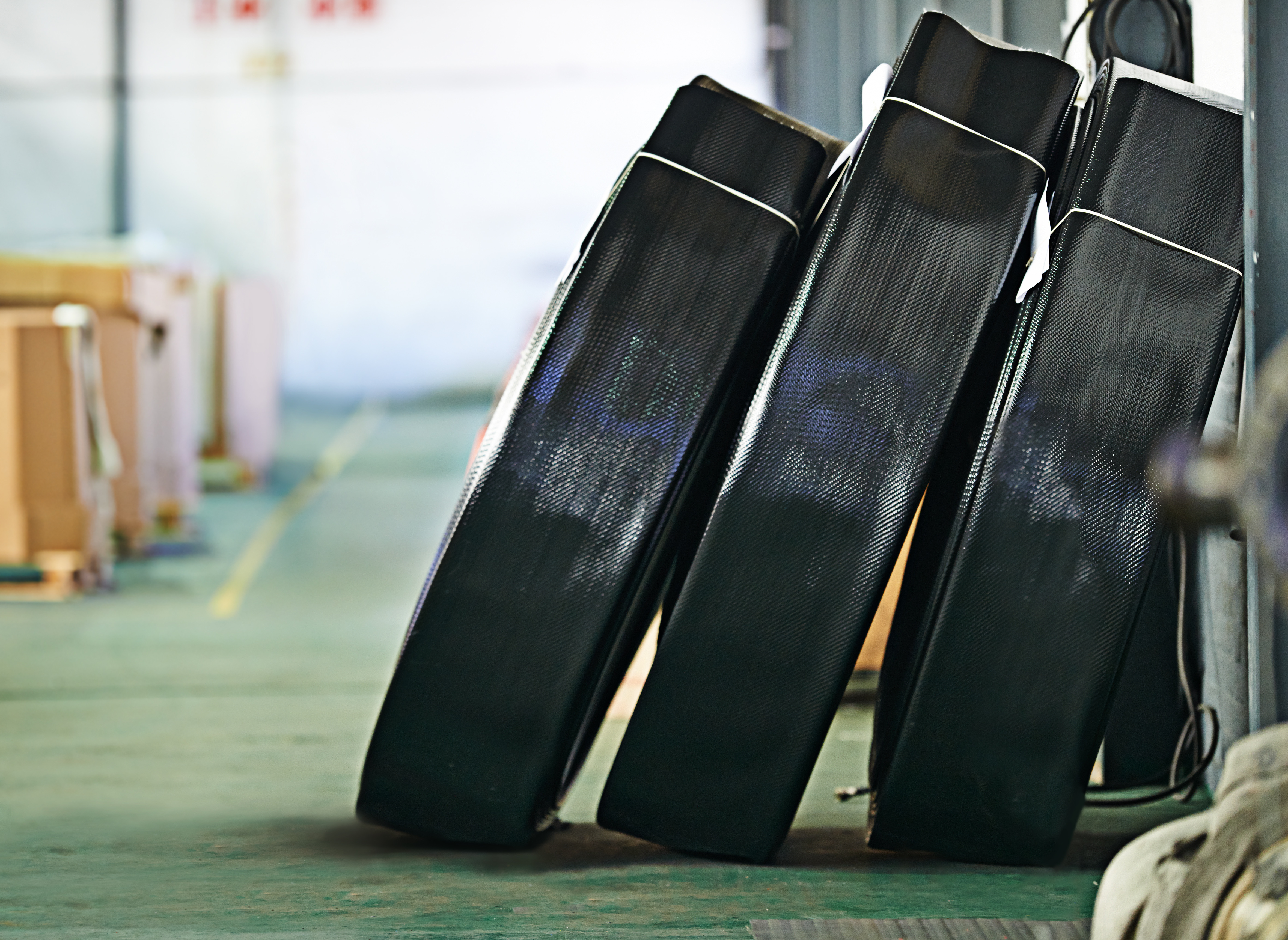 dark composite material bundles stacked in a workshop