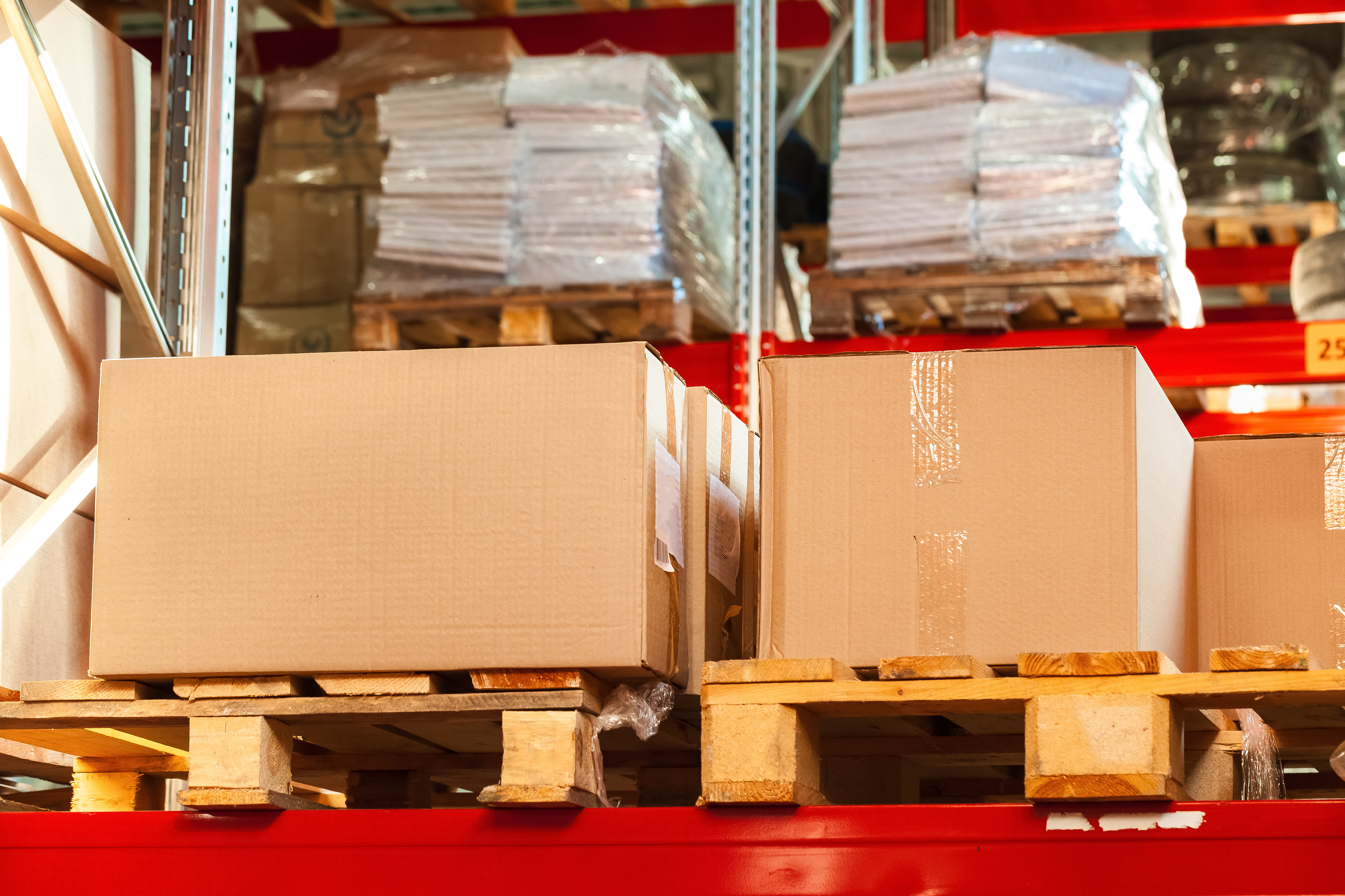 warehouse shelves with stacked carboard boxes on pallets