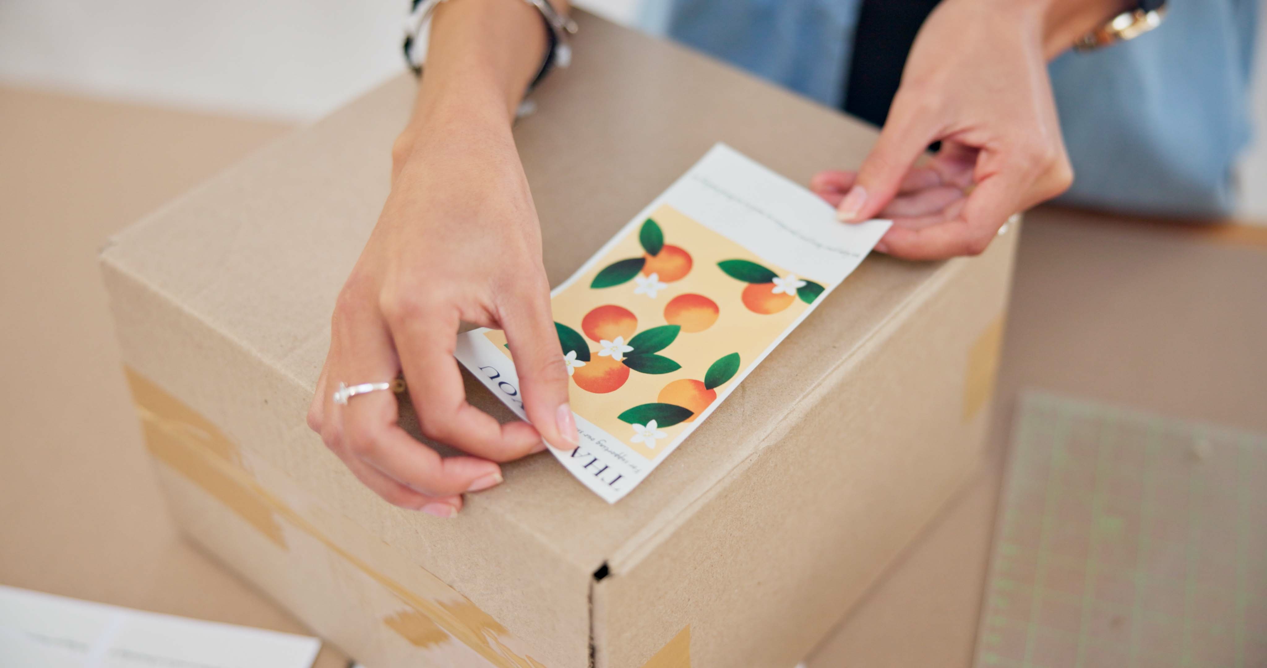 placing a custom sticker on a shipping box