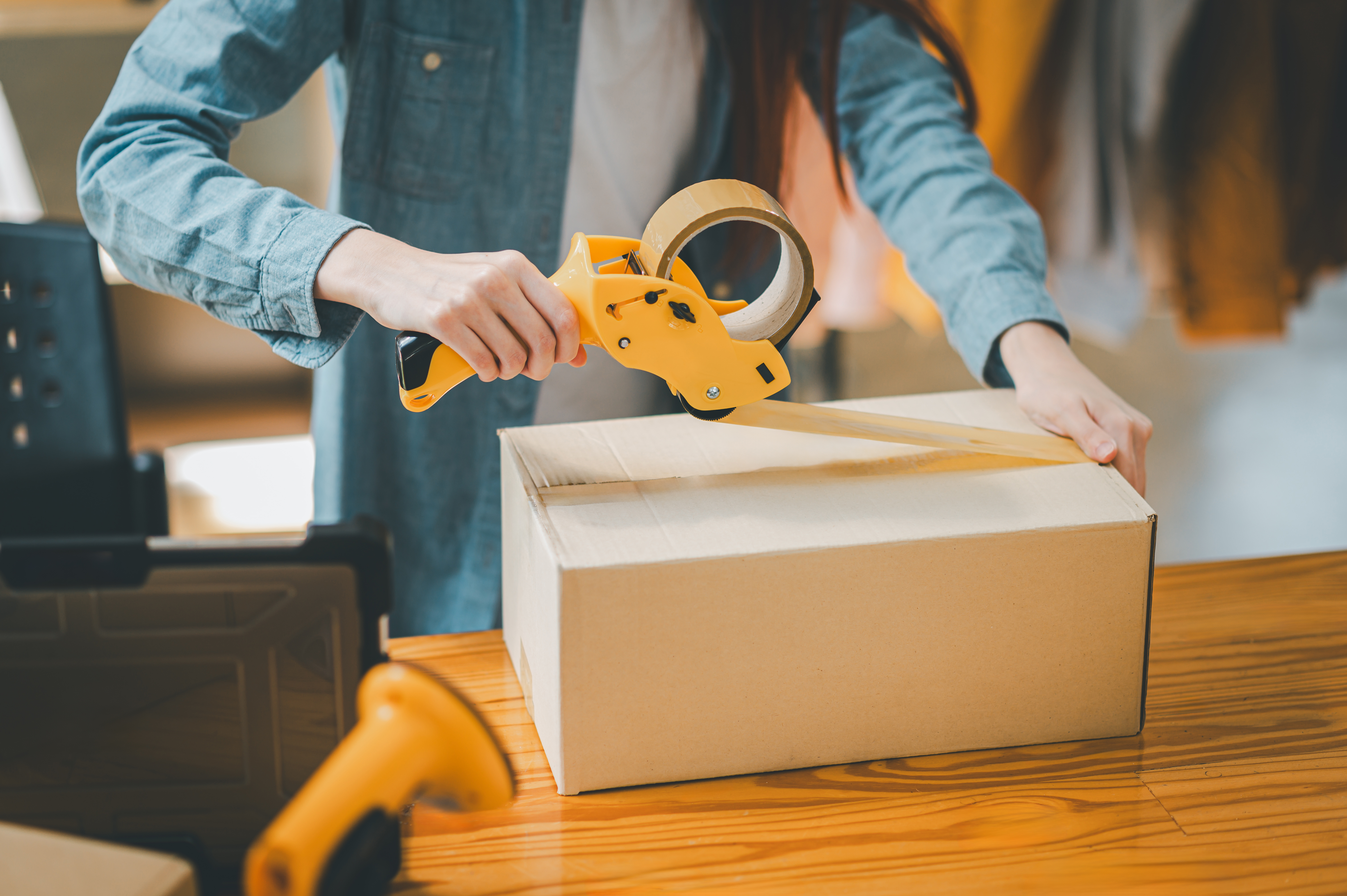 Woman taping up a cardboard box