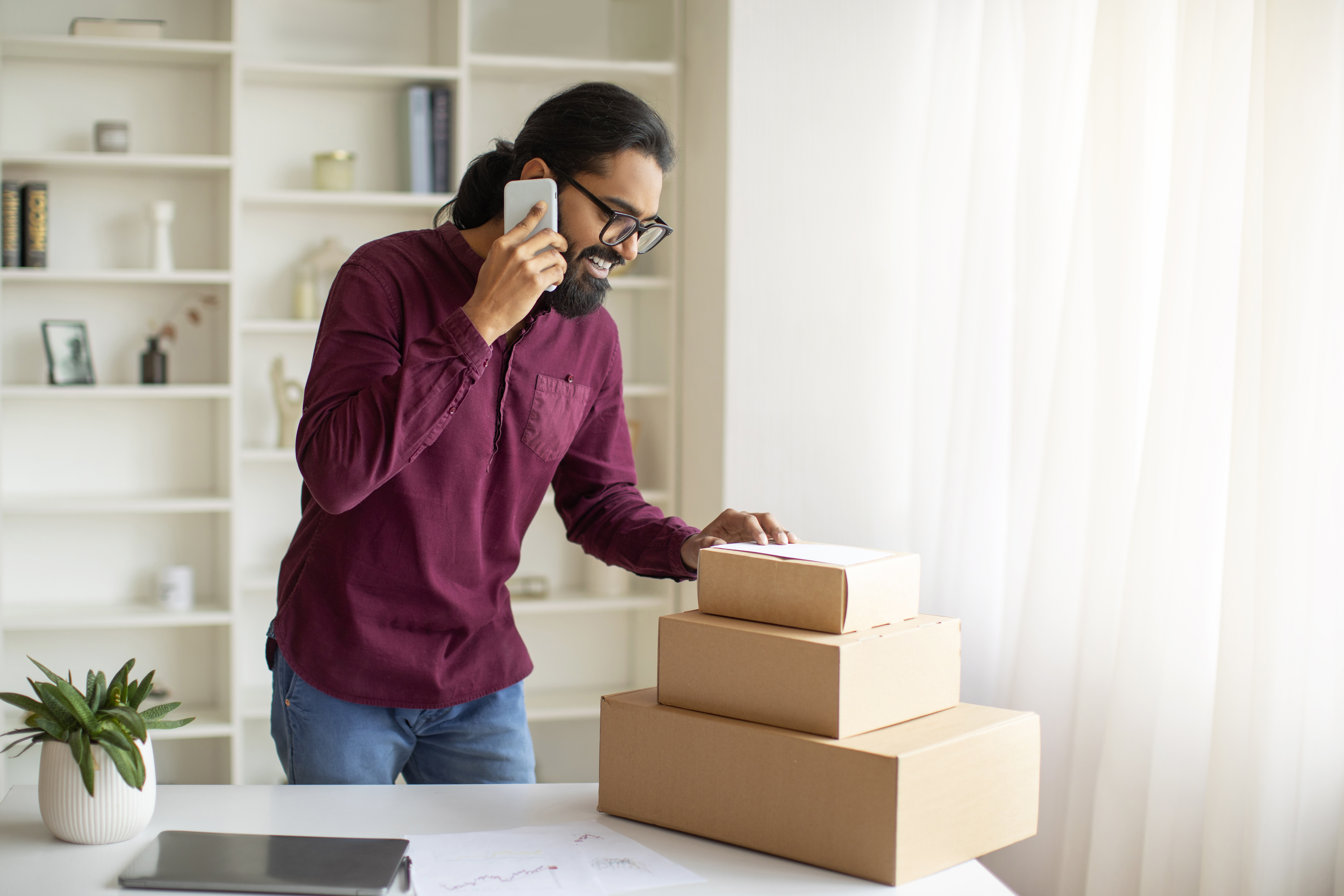 man packing orders and talking on the phone