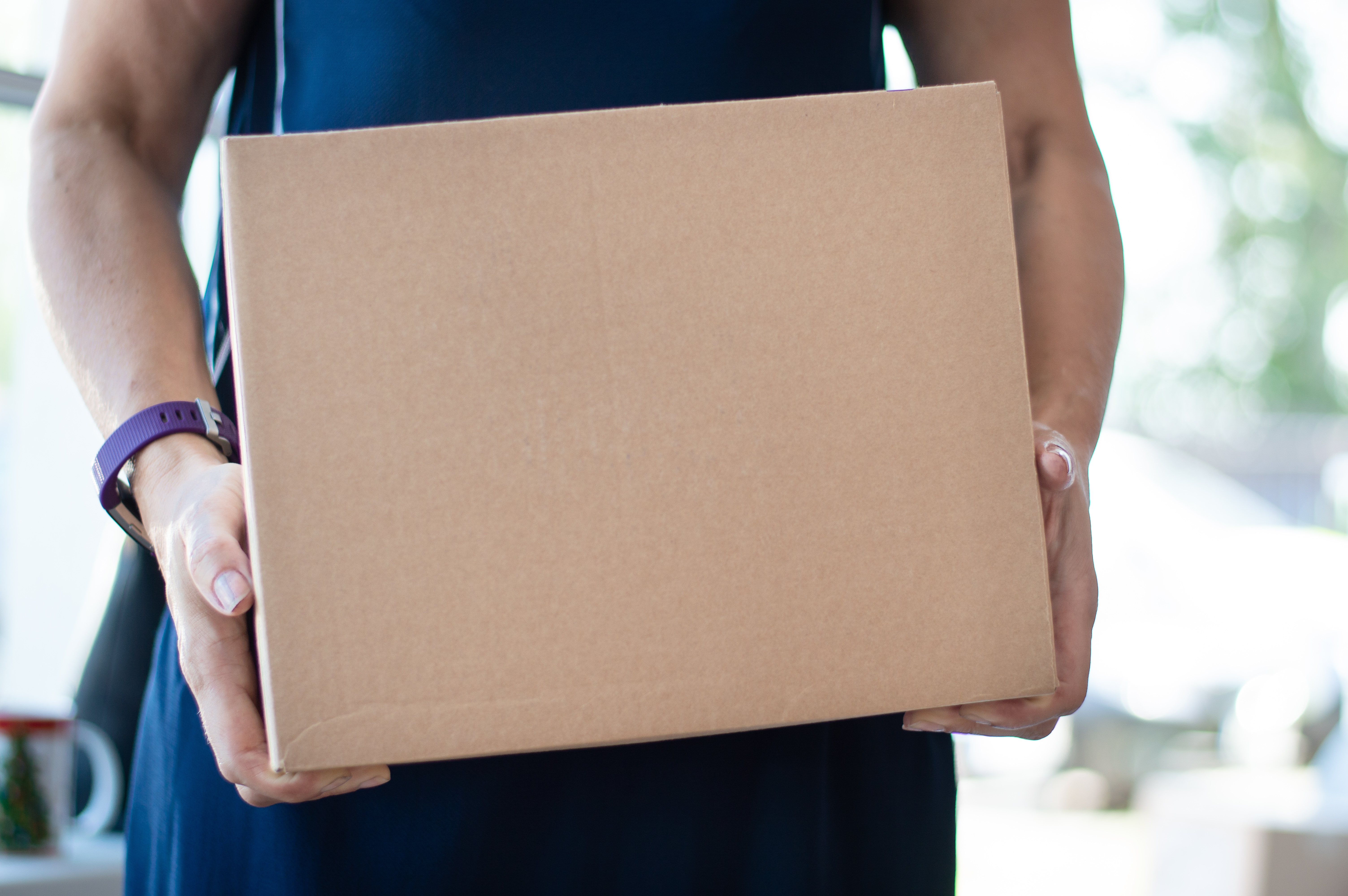 man carrying a medium sized cardboard box