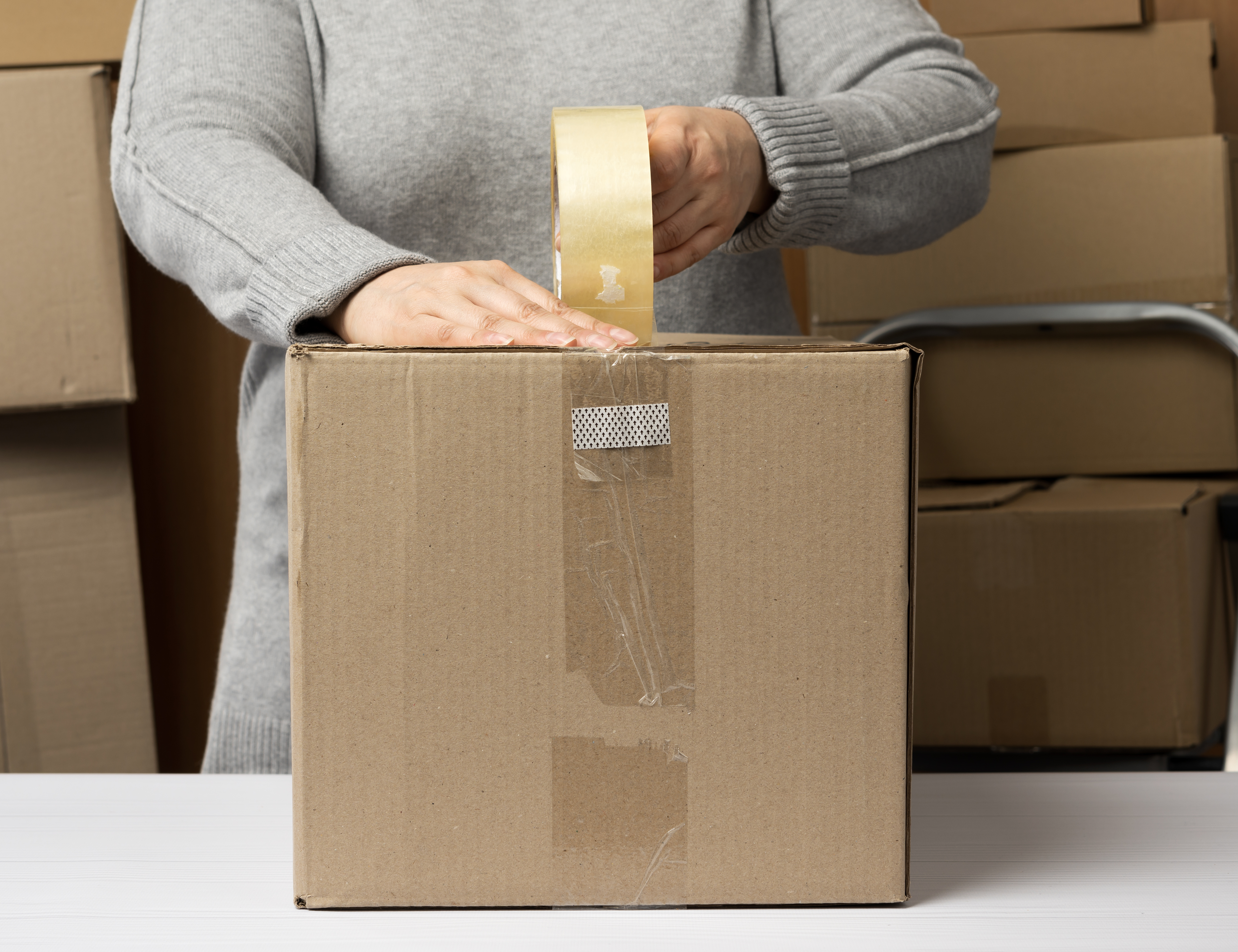 woman taping carboard package